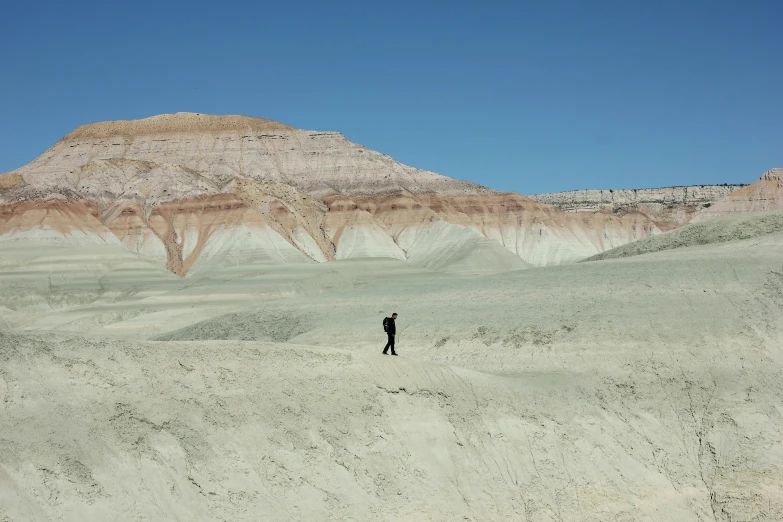 a lone person standing alone in an arid desert