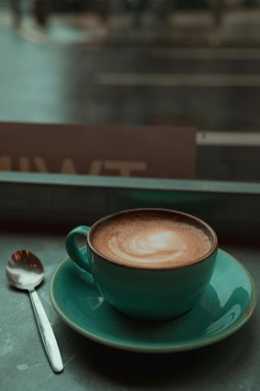 there is a coffee cup and a spoon on the table