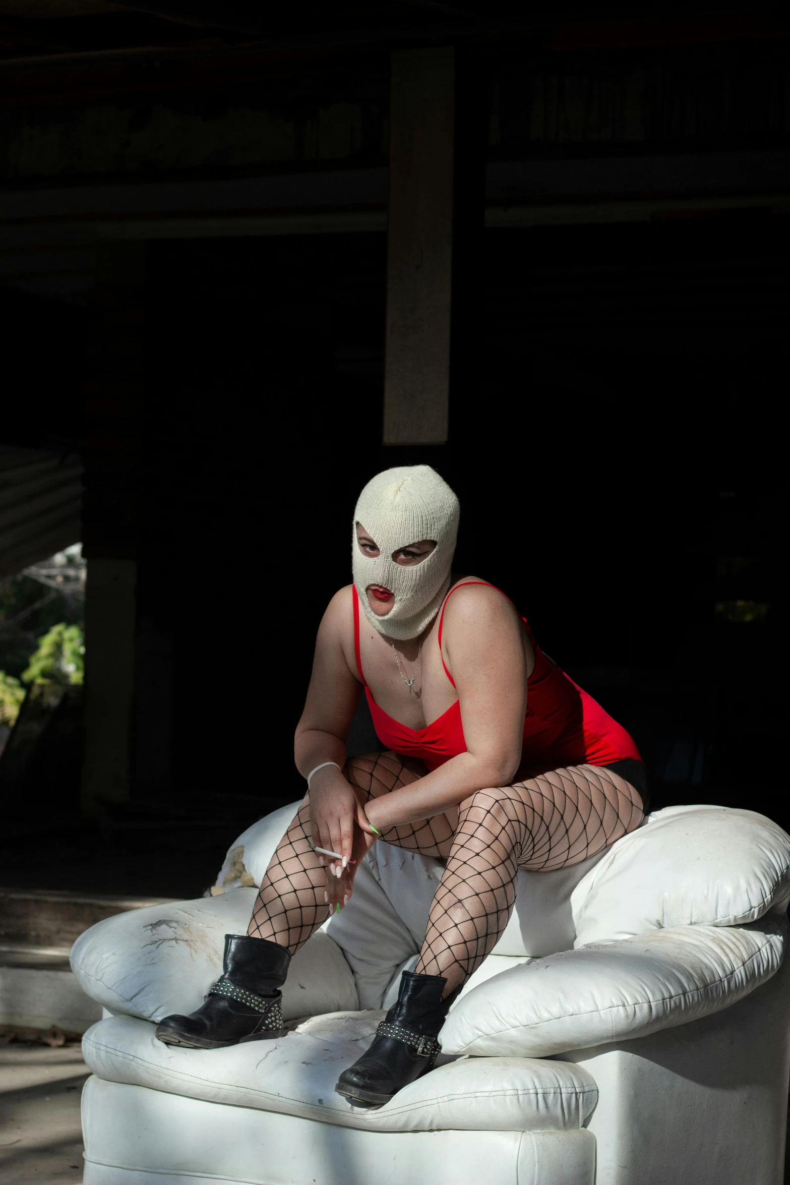 a person with white paint on their face and leg sits on an inflatable sofa