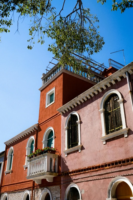 a pink building with two balconies and an upper - balcony