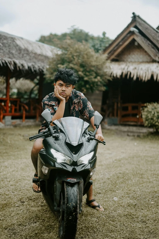 a man sitting on the front of a parked motorcycle