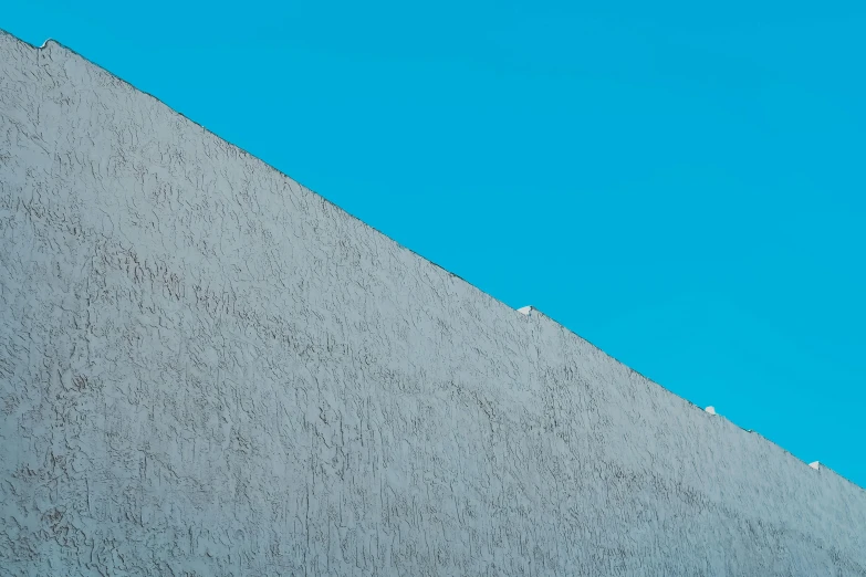 the bird is standing on the ledge of a building