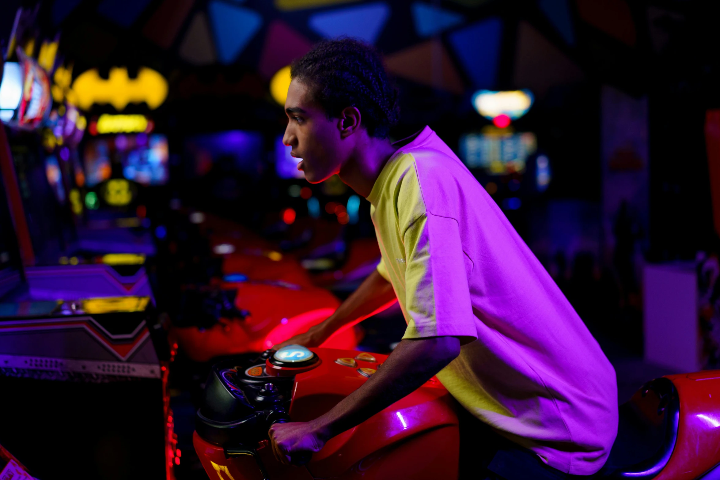 a man in a yellow shirt sits on a red motor scooter