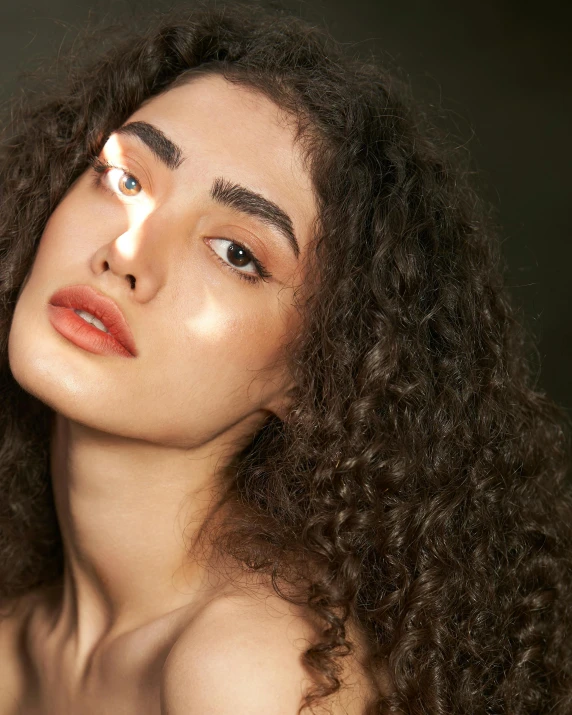 a woman with curly hair stares off to the side