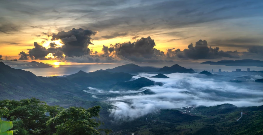 a sunset on a mountain with fog rolling in