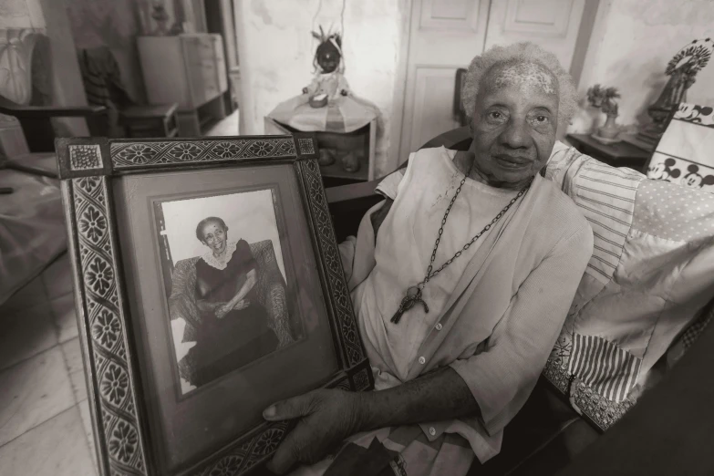 a woman that is sitting down with some framed pictures