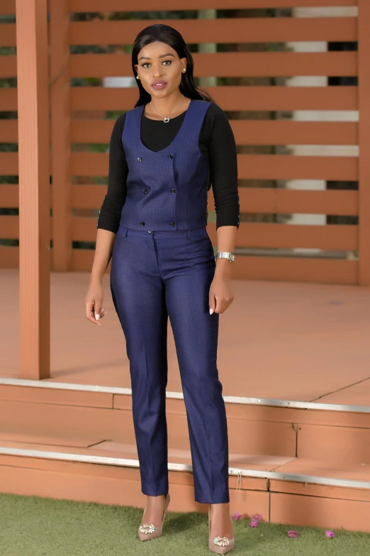 a woman in overalls poses on a set of steps