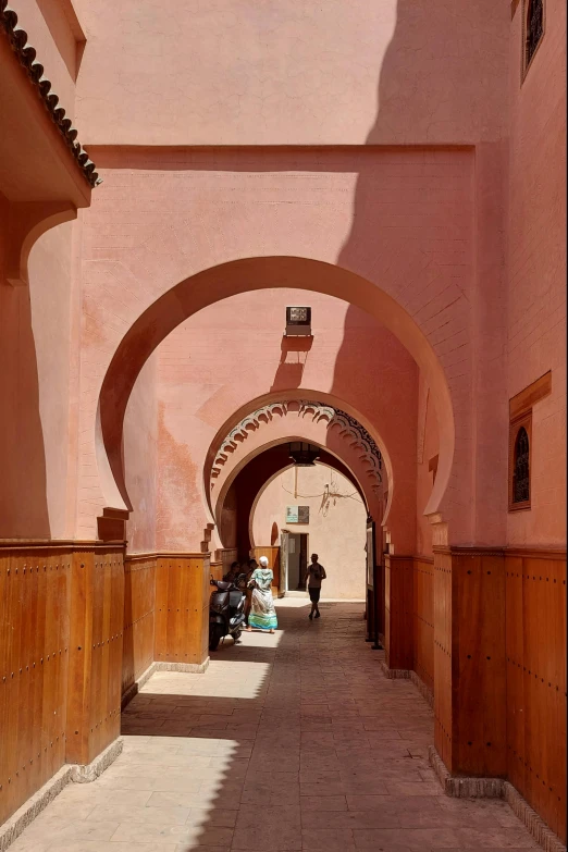 an alley way is decorated with pink buildings