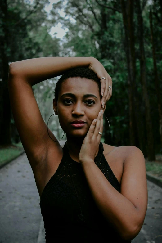 woman with hand on head standing in park