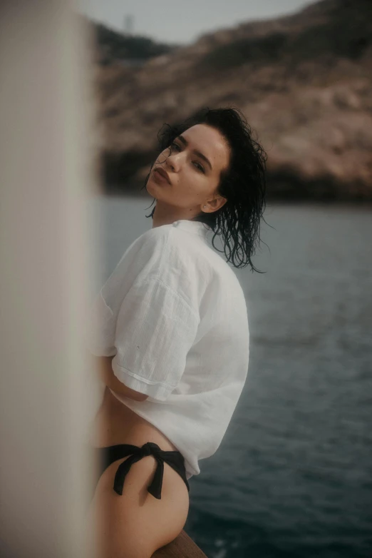 a young woman poses in front of the ocean