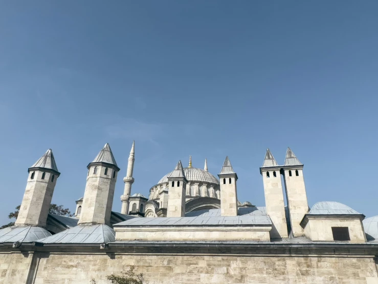 a tall building has lots of towers and a clock on it