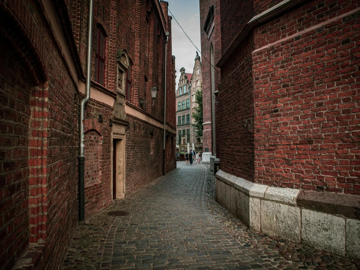 a narrow brick alley way with buildings on both sides