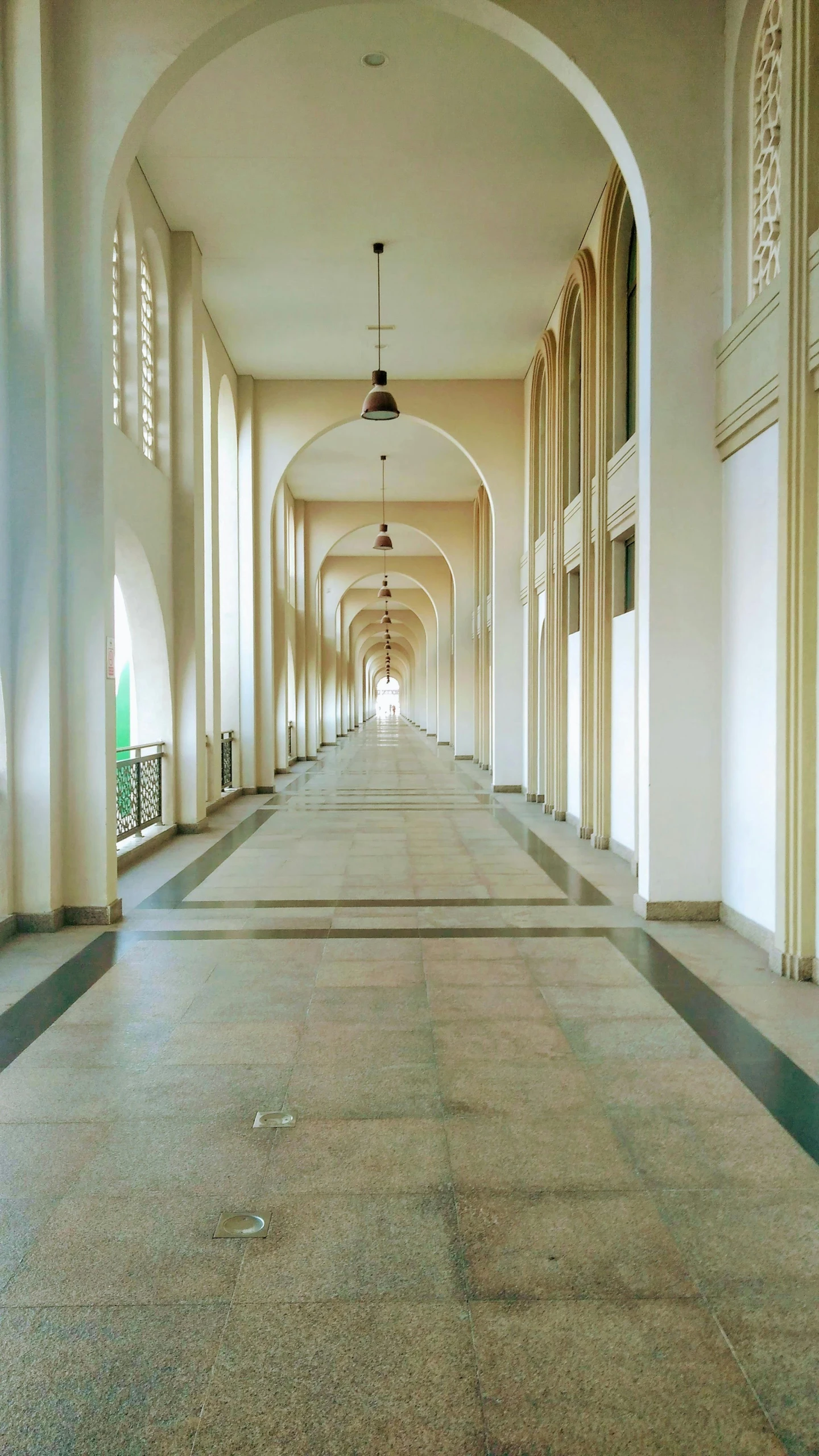 an empty hallway is filled with pillars and windows