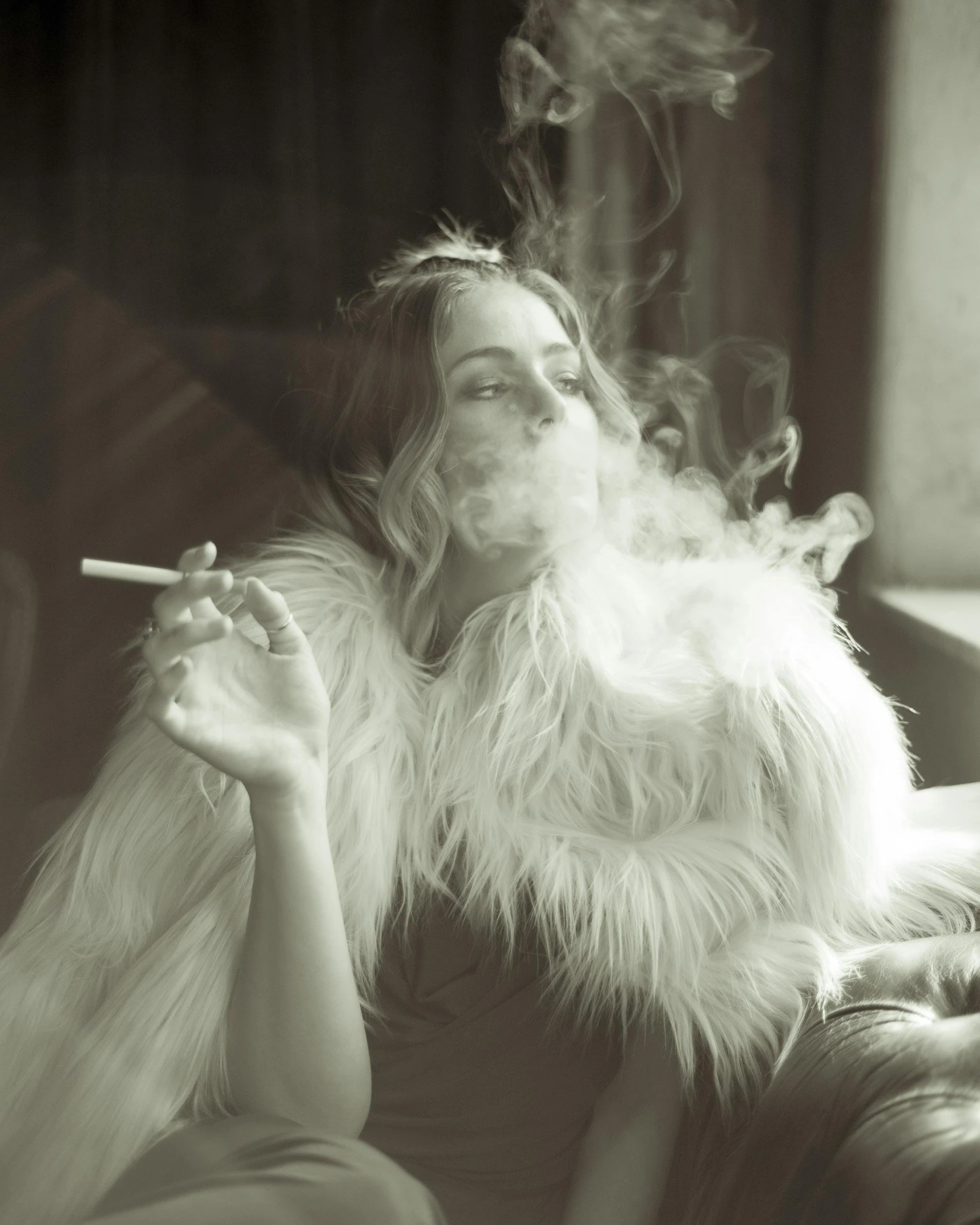 an older woman sitting on a couch smoking a cigarette