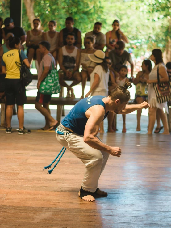 a man stands with his hand to his face as people look on