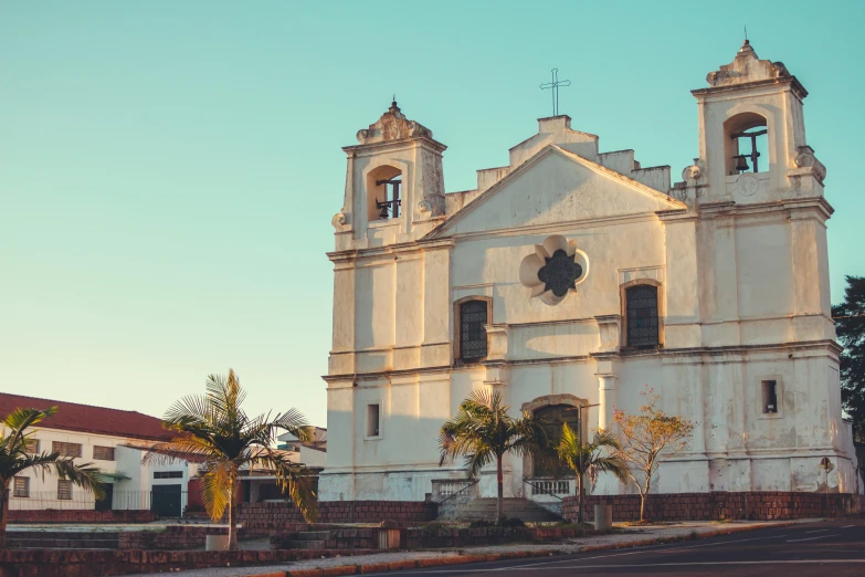 the front of a large white church with steeples