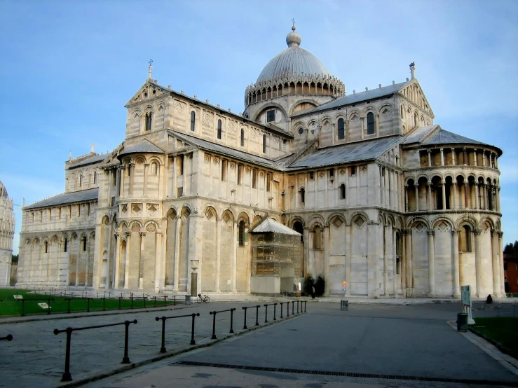 an old building with tall steeples sitting on a concrete pavement