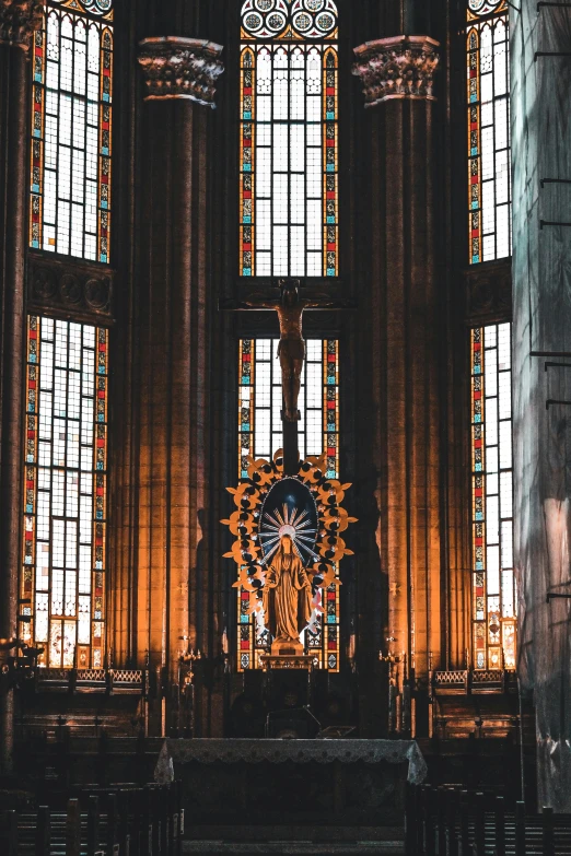 a stained glass window behind a pew in a church