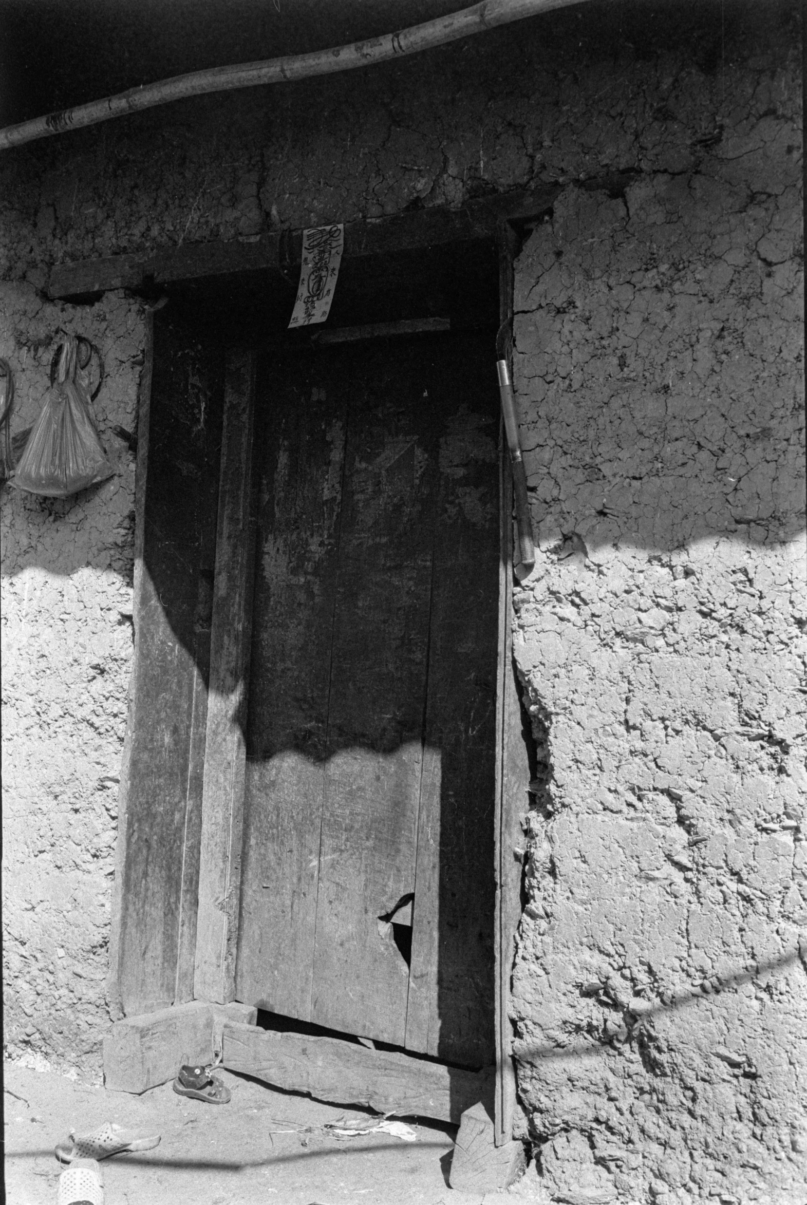 old po of doorway with graffiti on the side of an adobe house