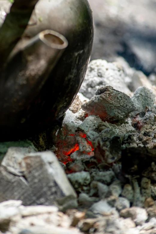 there is a clay pot sitting on some rocks