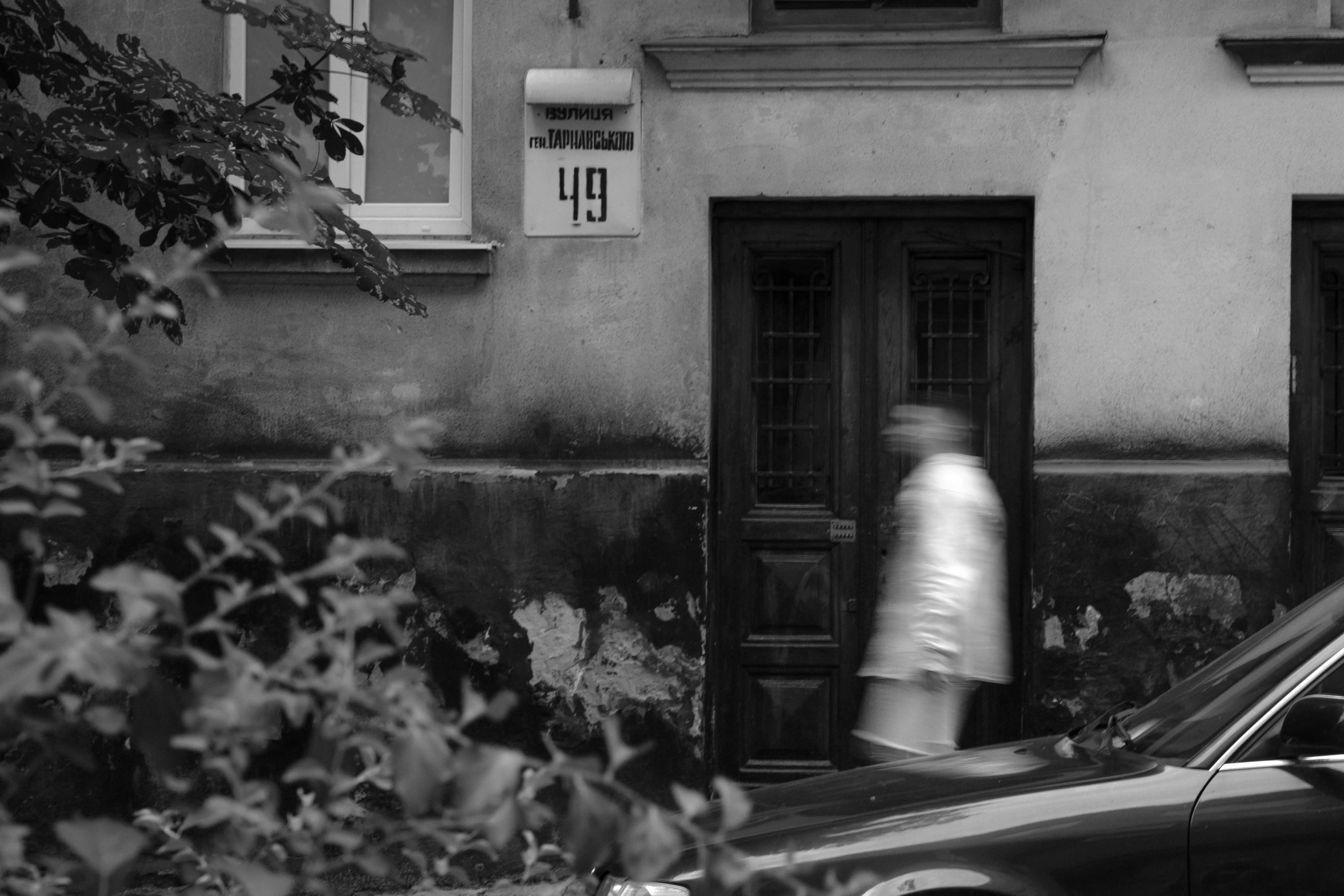 a car and a person walking by the door