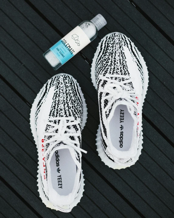 a pair of white sneakers next to an oral floss