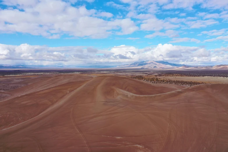 a road in the middle of a field with mountains in the background