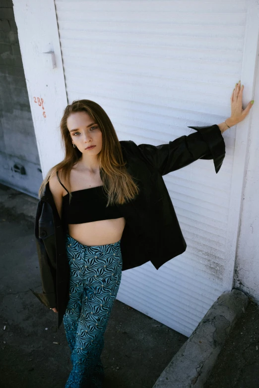 young woman leaning on the wall posing for picture