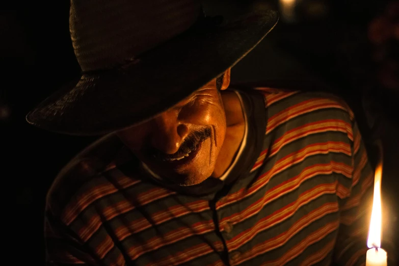 a close up of a man with a candle in his hand