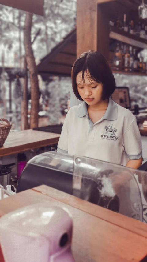 a girl sitting at a restaurant bar wearing a shirt