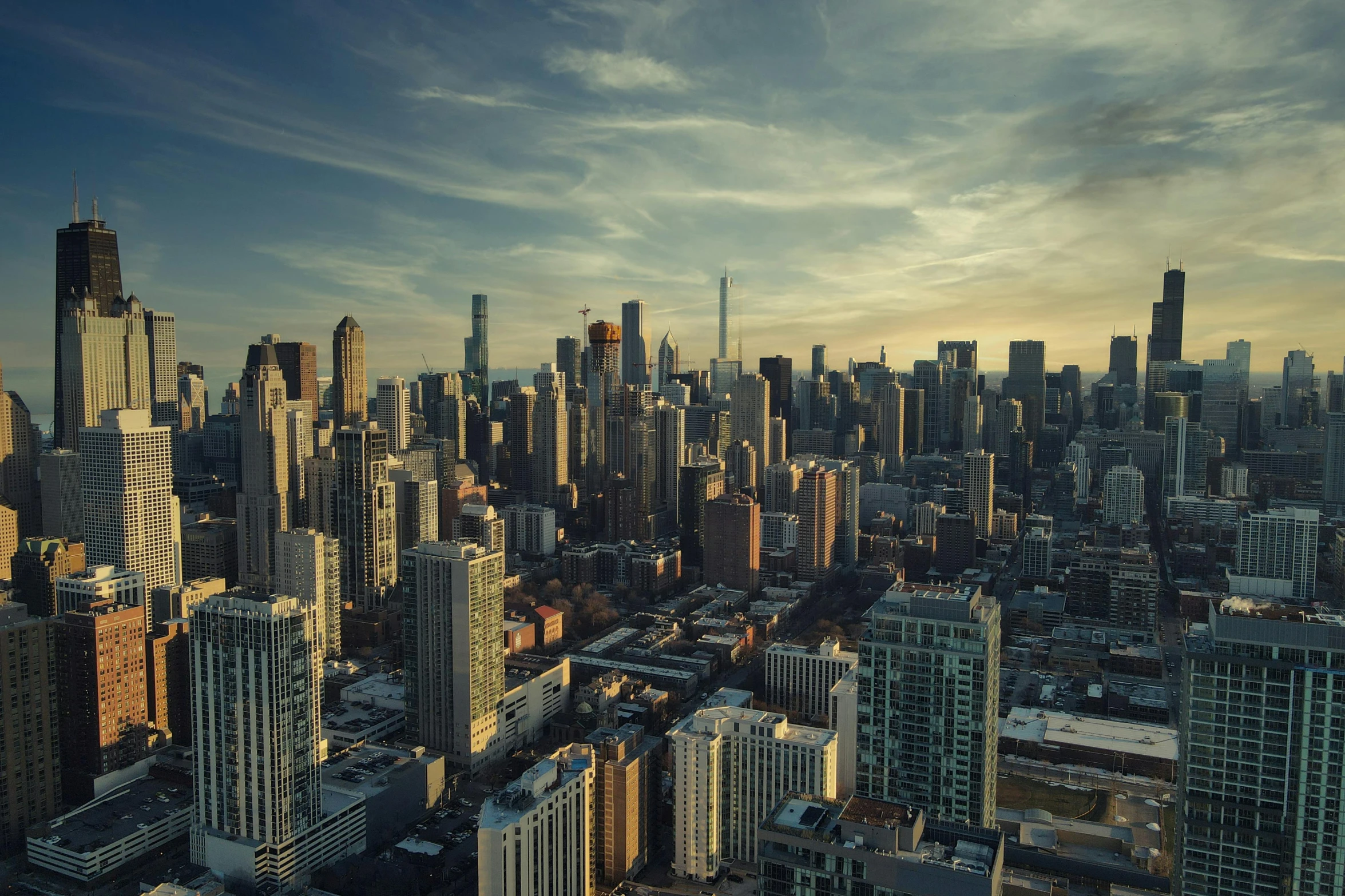 an aerial view of the city with skyscrs at sunset