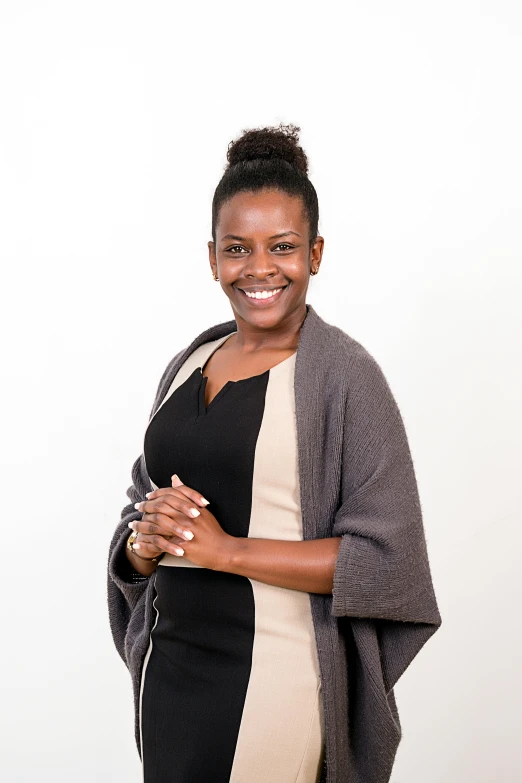 a woman smiles in front of a white wall