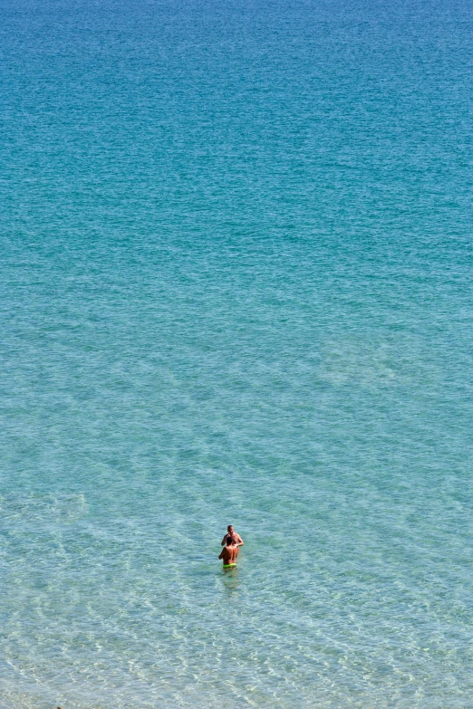 people standing in the water of a very big lake