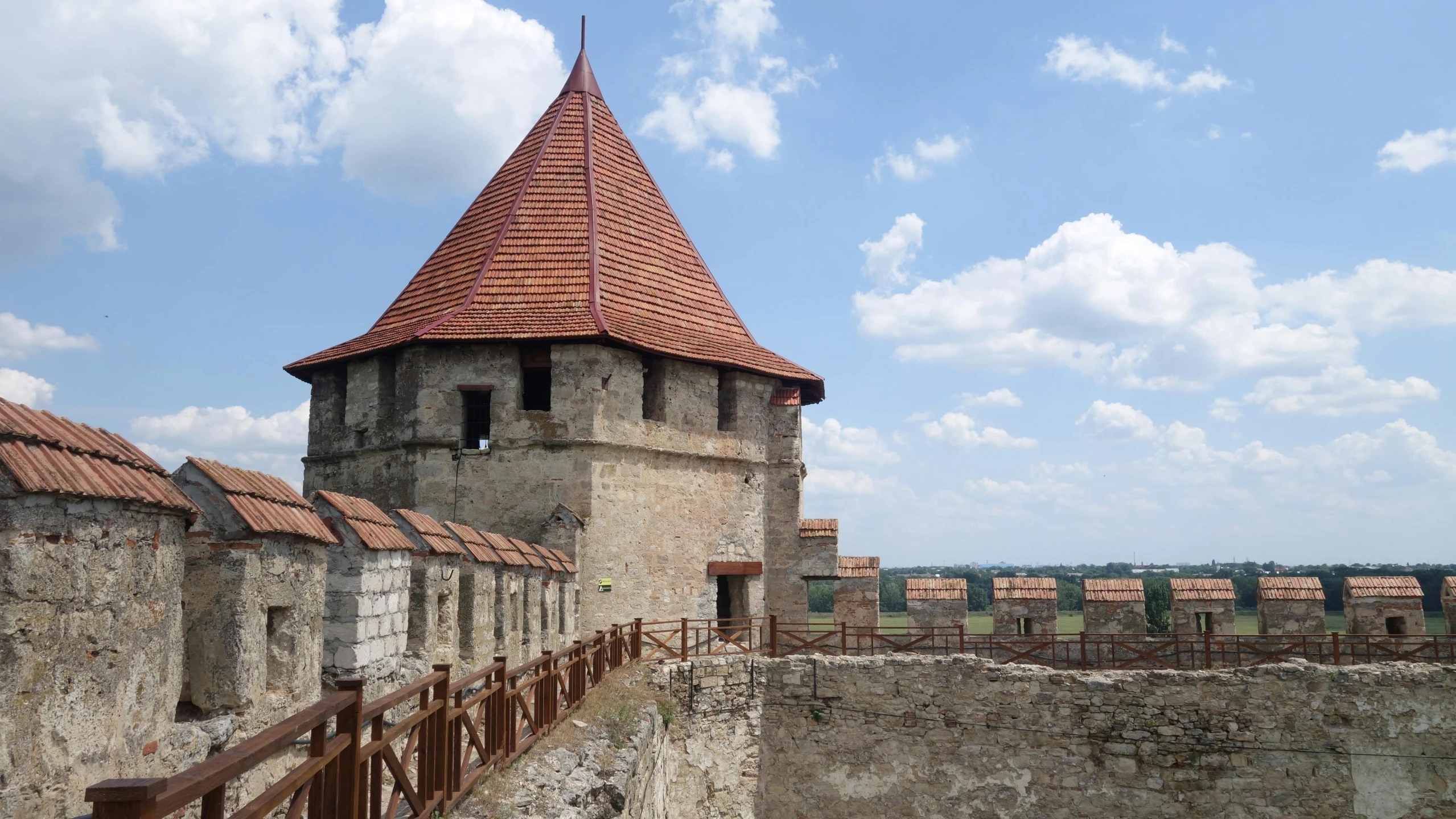 a stone and brick building with a tower in front of blue sky