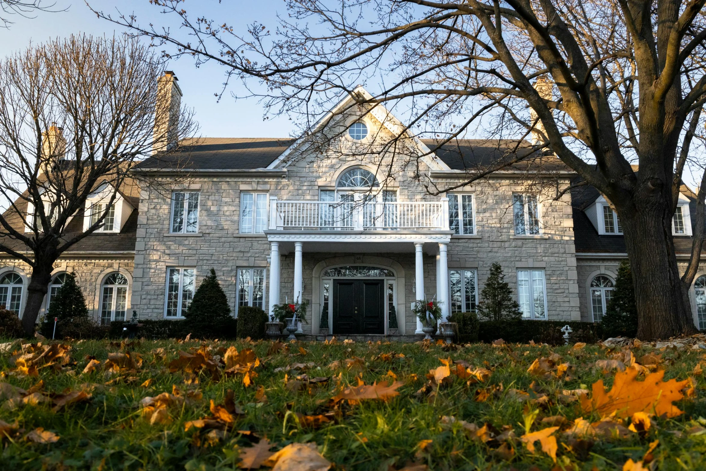 a large brick home surrounded by leafy trees