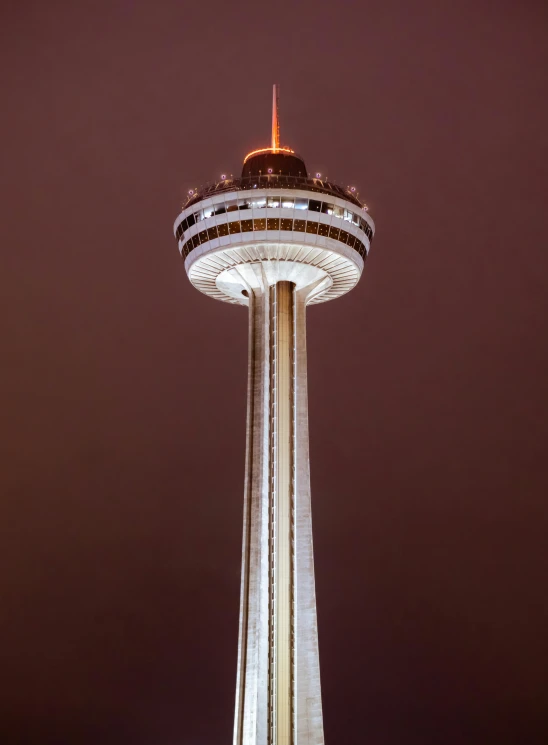 the top of a tall tower lit up at night