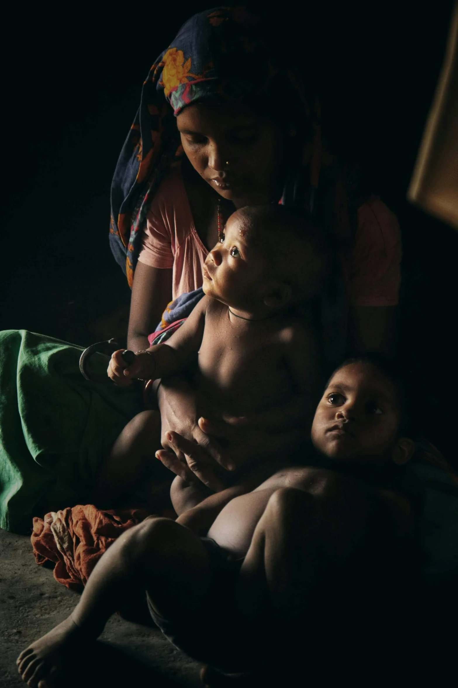 three women are holding a baby while they look at each other