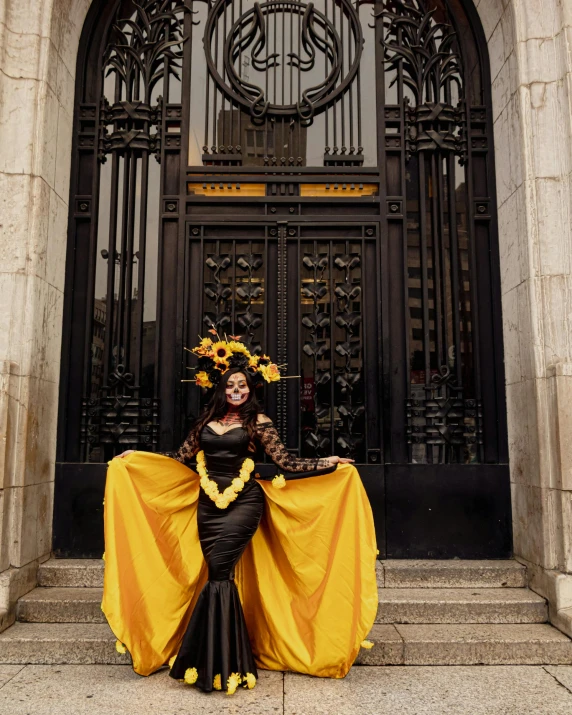 a woman in an elaborate dress posing on steps