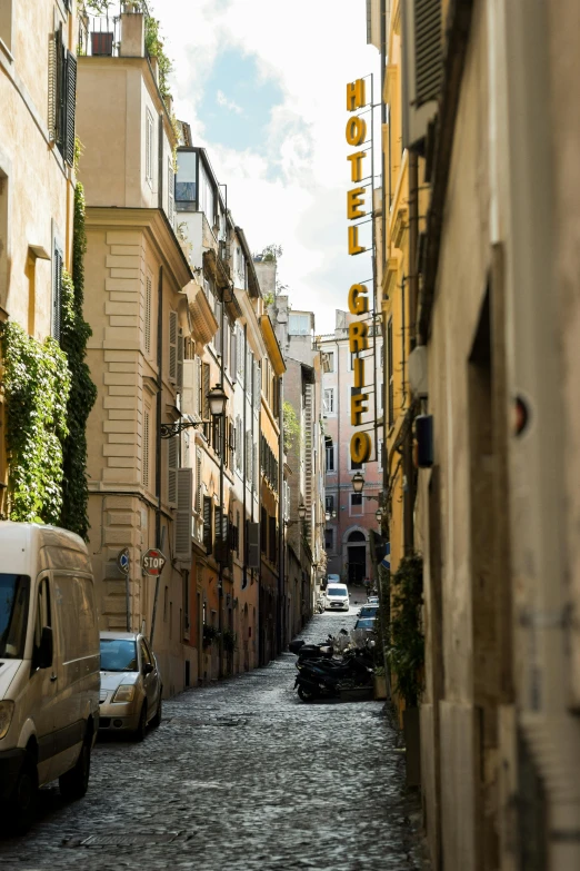 a small city street with a el sign above it