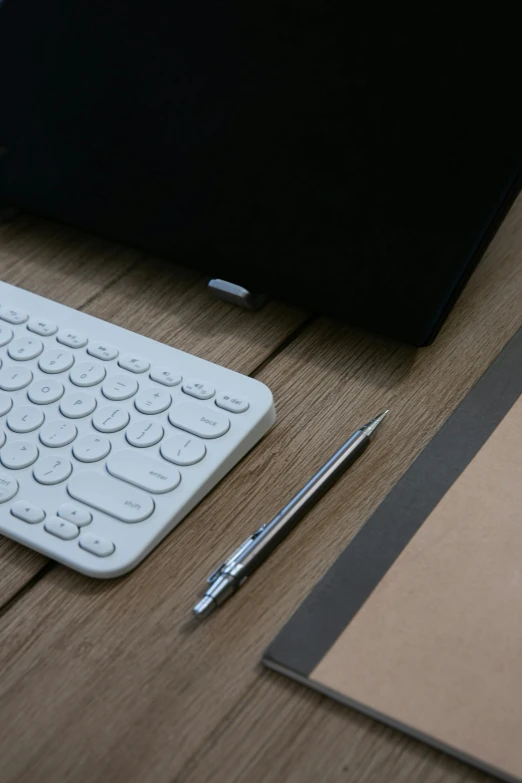 a desk with a keyboard and pen
