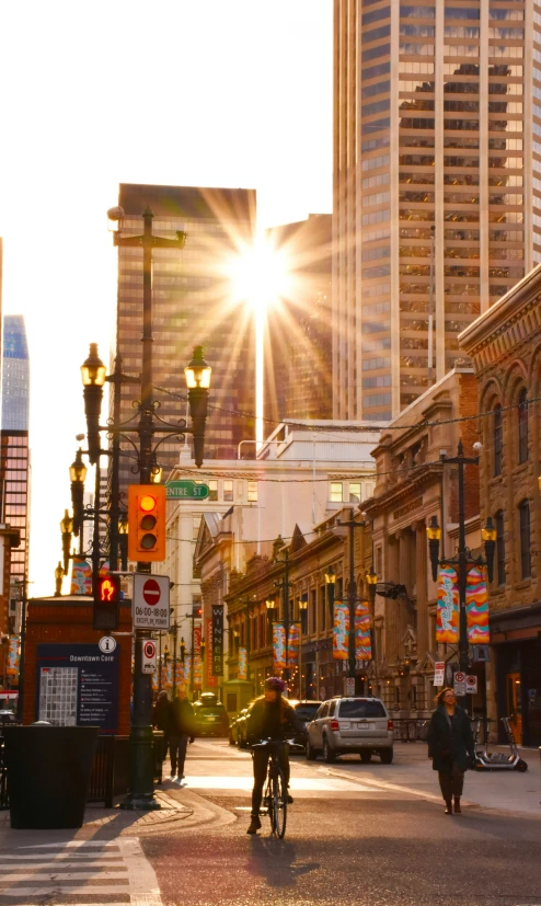 a man riding a bike on a street past tall buildings