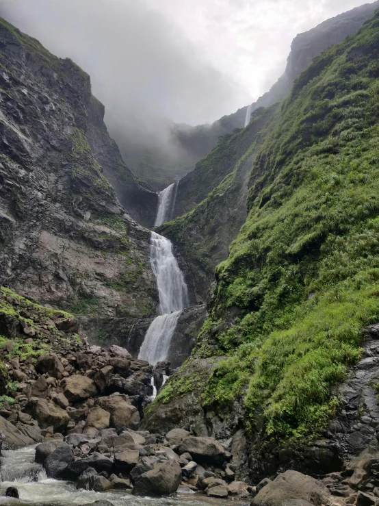 a small waterfall in the middle of a rocky mountain