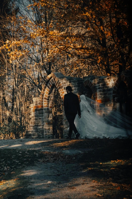 the lone person walks through an archway in a park