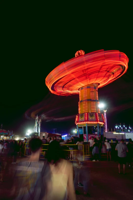 there is a red illuminated carnival at night