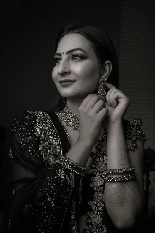 a woman is putting on some earrings and holding one of her hands