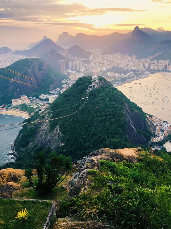 the sun is setting behind a mountain near a city