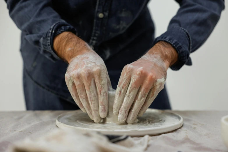 a person with gloves on holds onto a doughnut