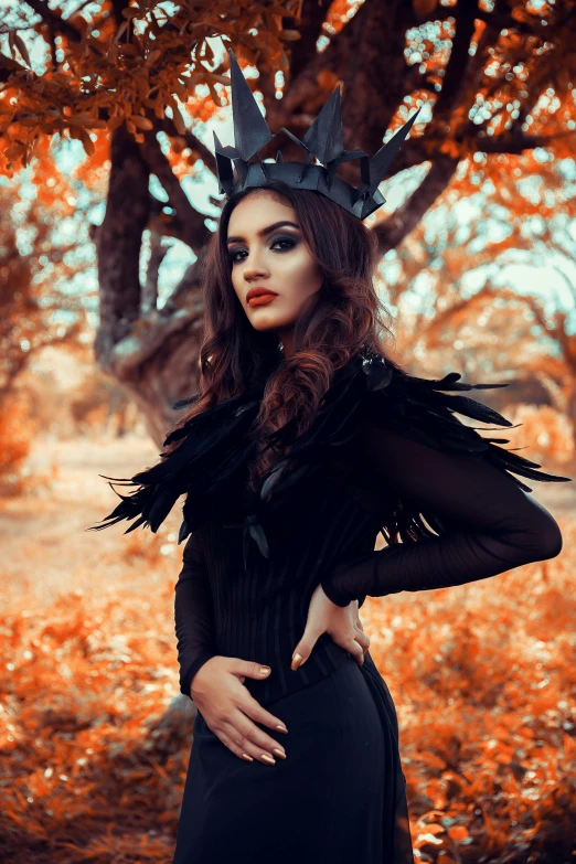 a girl standing under a tree wearing a crown