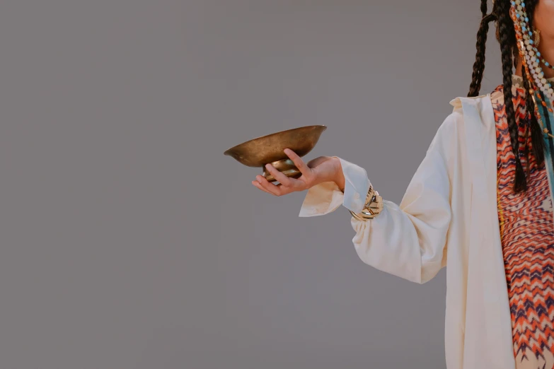 a person wearing long ids holding a plate and a bowl