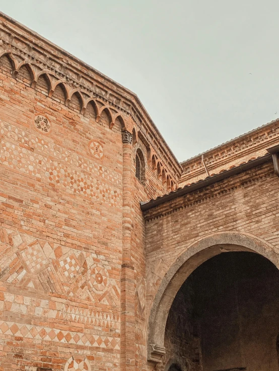 an arched brick wall is next to a clock tower